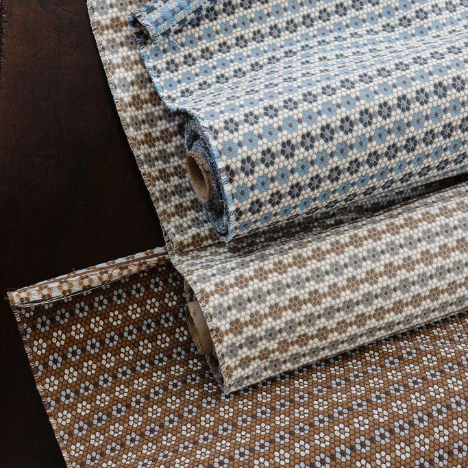 Rolls of Nectar woven fabric in cerulean blue and walnut