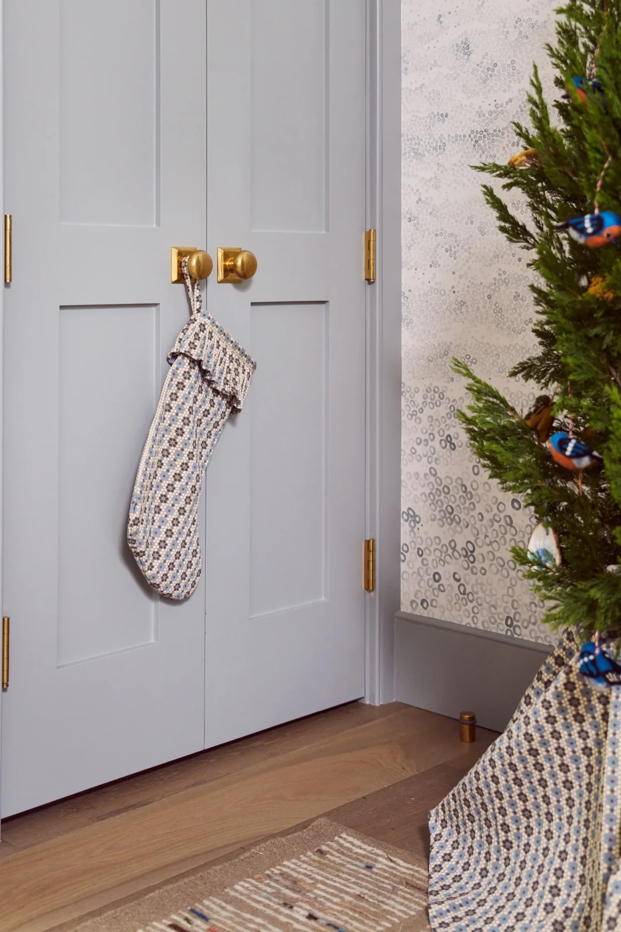 Patterned Christmas stocking hanging from a gray-blue closet door