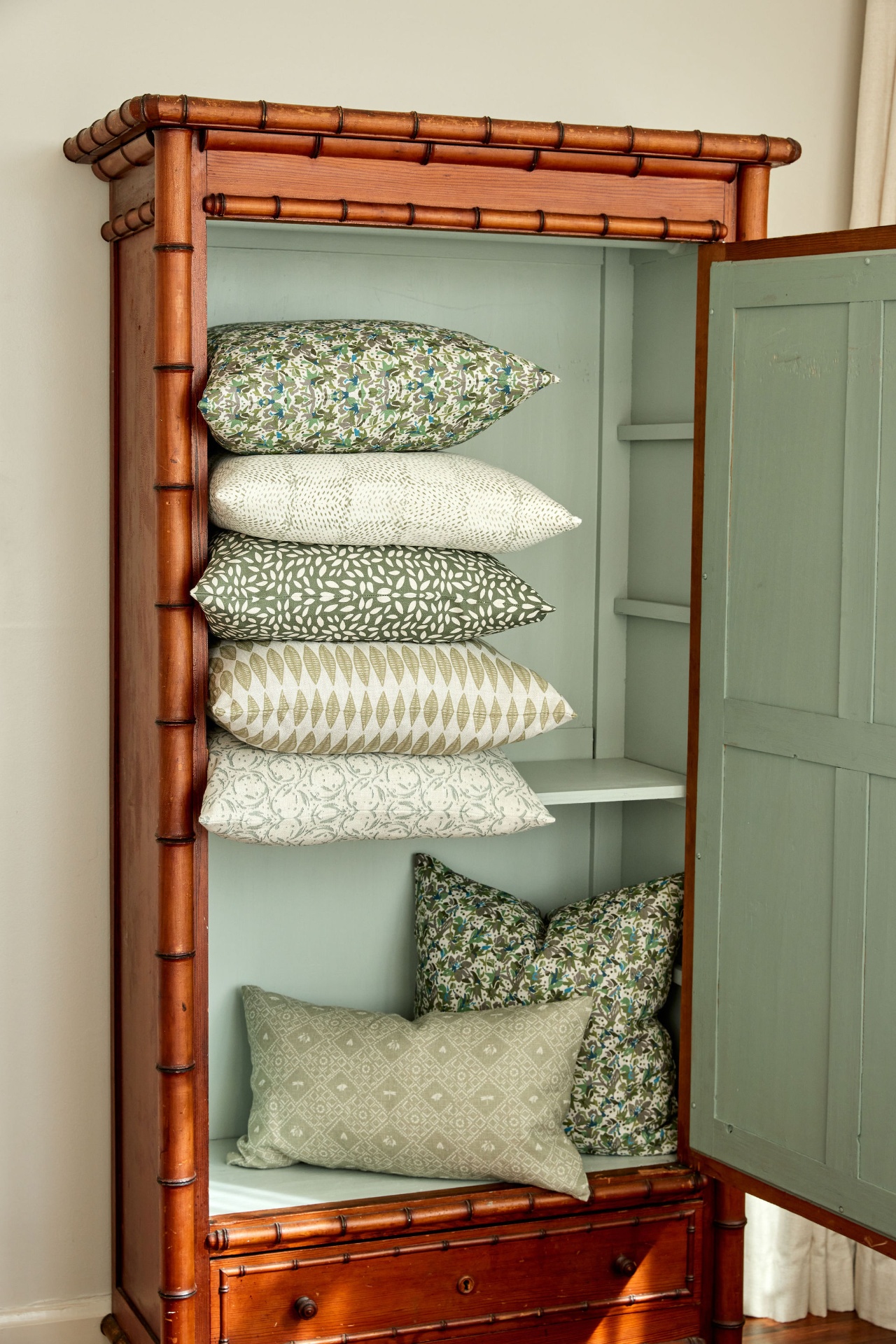 Fauna pillows stacked in a bamboo armoire