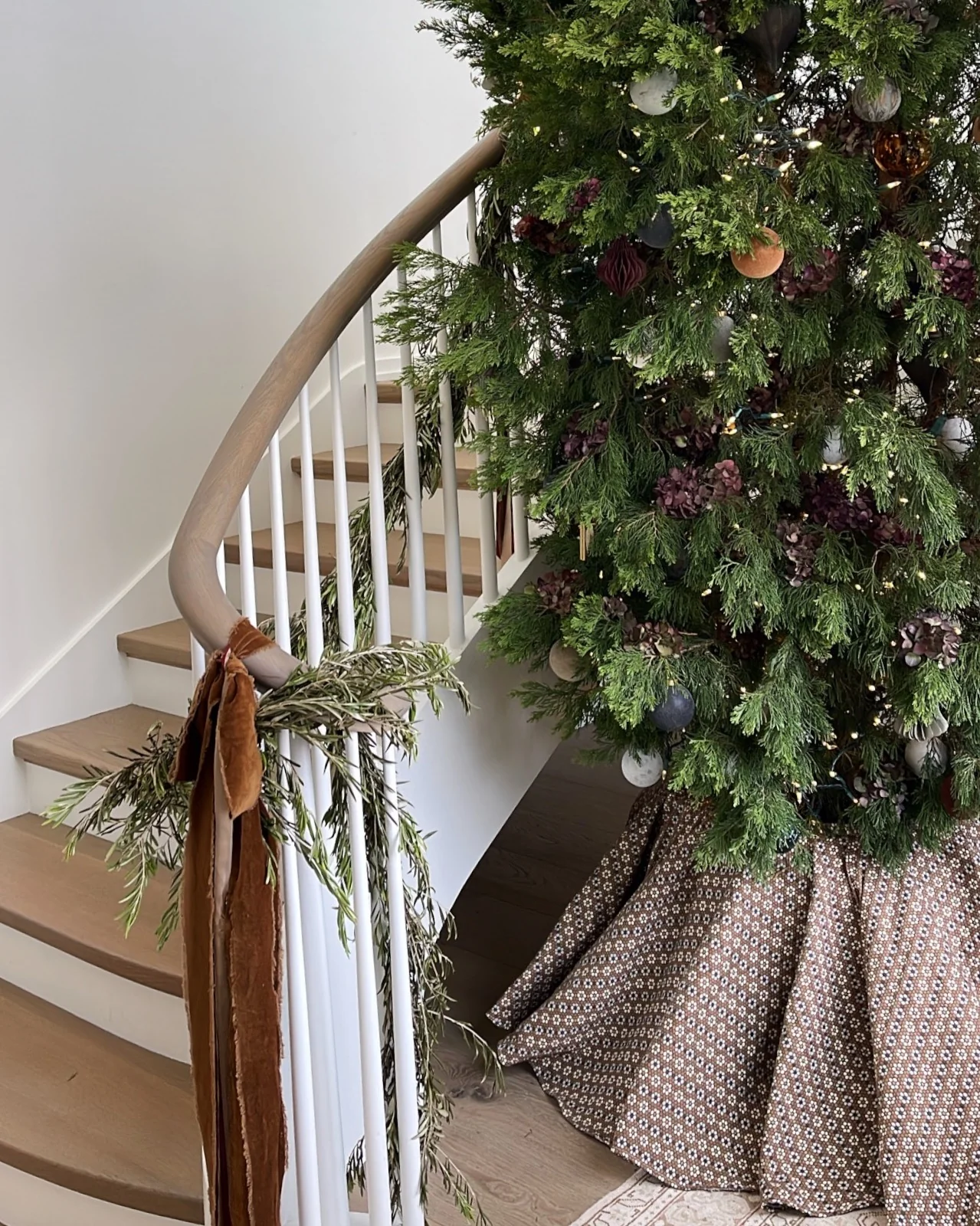 Cedar Christmas tree with a Nectar Walnut tree skirt beside a curved staircase