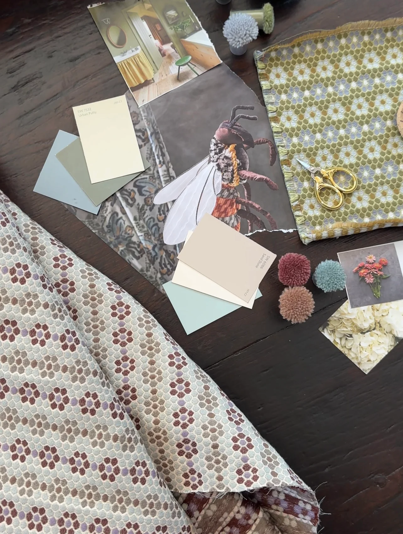 Nectar fabric with paint chips and pom-poms on the studio table