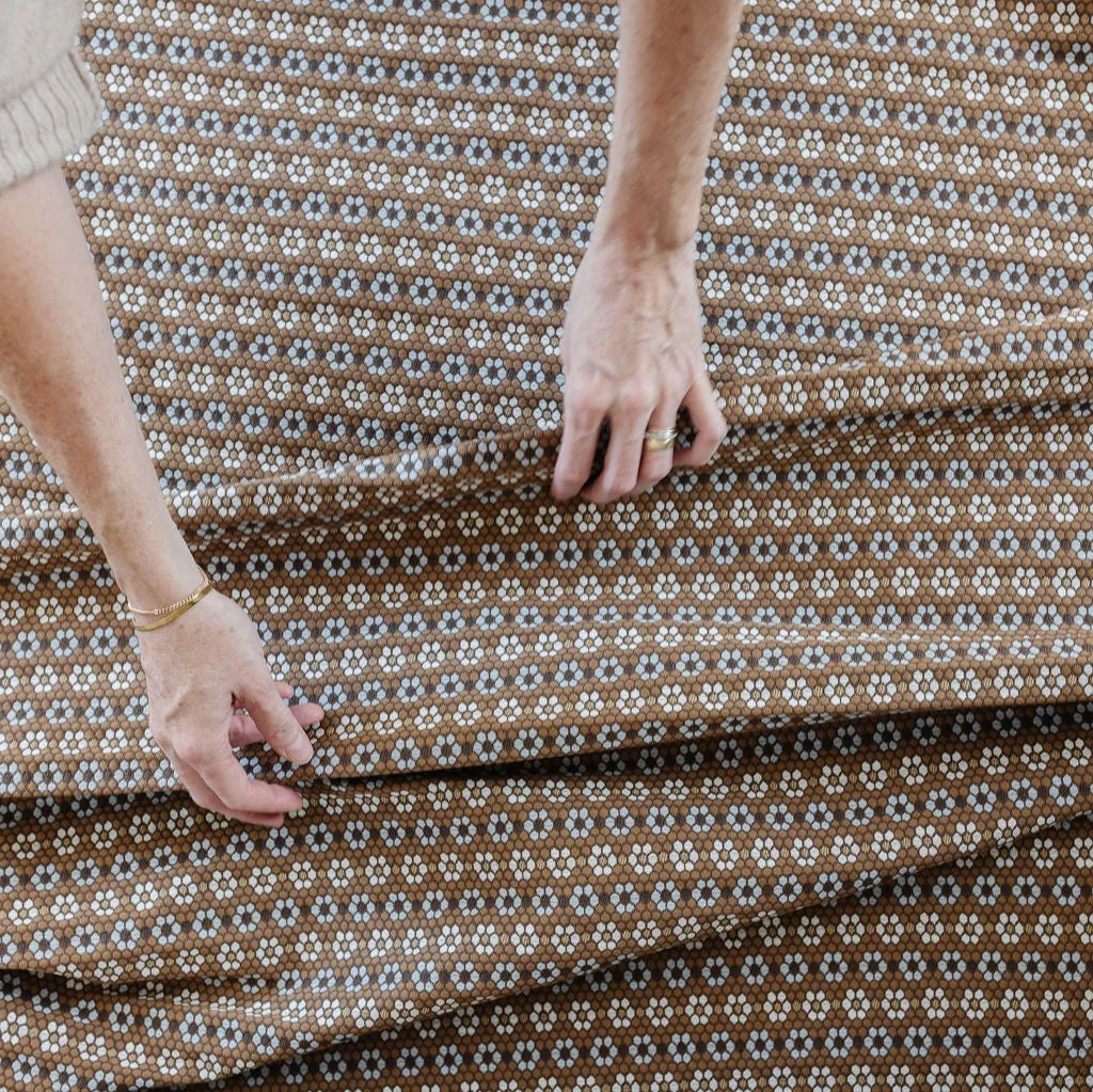 Close-up of hands smoothing Nectar in Walnut fabric